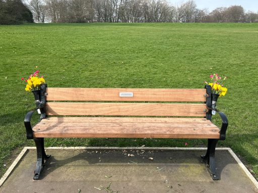 Seat of the bench with inscription and flowers