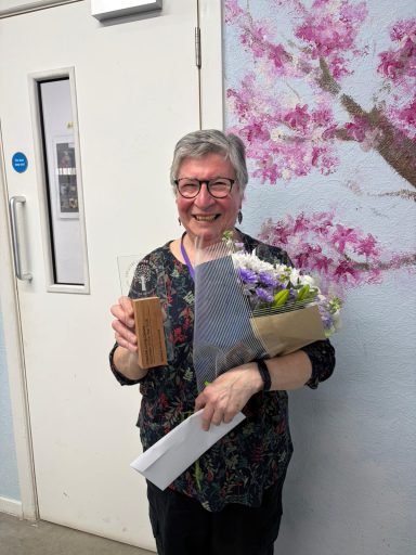Helen with the trophy, prize and flowers